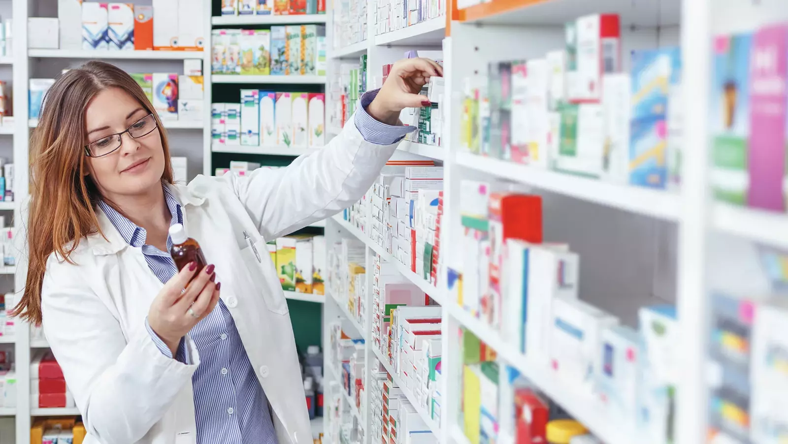 woman pharmacist holding bottle of medicine