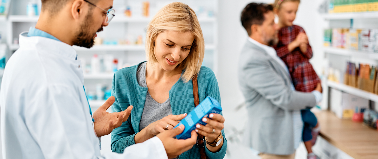 male pharmacist helping family at the pharmacy 